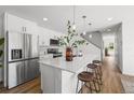 Stylish kitchen featuring stainless steel appliances, white cabinets, and a large center island with bar stools at 1335 N Alton St, Aurora, CO 80010