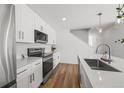 Modern kitchen with stainless steel appliances, white cabinets, and hardwood floors at 1335 N Alton St, Aurora, CO 80010