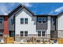 Striking townhome exterior featuring stone accents, mixed siding, and a vibrant turquoise front door at 2887 E 103Rd Dr, Thornton, CO 80229