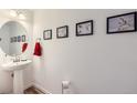 Stylish powder room with a vessel sink, trendy lighting, and decorative wall art at 7987 Yampa River Ave, Littleton, CO 80125