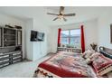 Bright bedroom features an oversized window, wall-mounted tv, and customized built-in storage at 7987 Yampa River Ave, Littleton, CO 80125