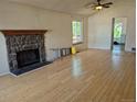 Spacious living room with hardwood floors, stone fireplace, vaulted ceilings, and natural light from large windows at 2750 S Rifle St, Aurora, CO 80013