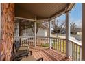 Cozy covered front porch with wooden flooring, white railings, and comfortable seating for relaxing outdoors at 19257 E Legend Ave, Parker, CO 80134