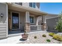 Inviting front porch with stone pillar bases, mature shrubs, and a welcoming entryway at 6065 Clover Ridge Cir, Castle Rock, CO 80104