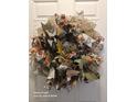 A charming, handcrafted autumn wreath adorns a white door, adding seasonal cheer at 14641 E Poundstone Dr, Aurora, CO 80015