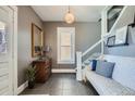 Bright foyer featuring tiled floors, a wooden dresser, and staircase with a white railing at 3249 N Clay St, Denver, CO 80211