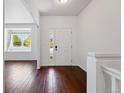 Bright foyer features hardwood floors, a white front door, and a view into the adjacent living space at 25077 E Canal Pl, Aurora, CO 80018