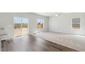 Bright living room with carpet and wood flooring plus large windows with natural light and sliding glass door at 7244 Arkansas St, Frederick, CO 80530