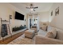 Bright living room featuring a comfortable sofa, balcony access, and a modern ceiling fan at 1841 S Dunkirk St # 207, Aurora, CO 80017