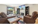 Comfortable living room with fireplace, sliding glass doors to fenced patio, and wood floors at 6462 E Bates Ave, Denver, CO 80222