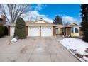 3-car garage, brick front, and partially visible snow at 6926 S Saulsbury St, Littleton, CO 80128