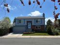Two-story home with blue trim, brick accents, and well-kept lawn, framed by flowering trees at 430 Chestnut Way, Broomfield, CO 80020