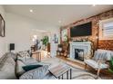 Stylish living room boasts exposed brick, a fireplace, and an open floor plan at 3384 W 29Th Ave, Denver, CO 80211