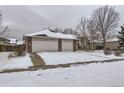 Brick home with a three-car garage and a snowy front yard at 646 N 13Th Ave, Brighton, CO 80601