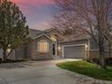 Charming home featuring a stone facade, inviting entrance, manicured lawn and a two-car garage with ample driveway parking at 7400 W Grant Ranch Blvd # 5, Littleton, CO 80123