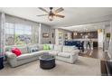 Open-concept living room and kitchen features a large sofa, ceiling fan, and natural light at 1382 Raindrop Way, Castle Rock, CO 80109