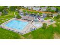 Aerial view of a community pool with lounging chairs, playground and green spaces at 2556 E 131St Pl, Thornton, CO 80241