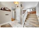 Welcoming entryway with white tile flooring, coat closet, and staircase to the upper level at 5050 W 102Nd Ave, Westminster, CO 80031