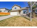 Two-story home boasts a two-car garage, front yard with mature tree and plentiful windows at 7835 Canvasback Cir, Littleton, CO 80125