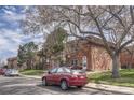 Brick townhouse with mature trees and a well-maintained lawn at 3614 W Radcliff Ave, Denver, CO 80236