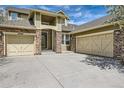 Close up of a lovely home with a three-car garage, stone accents, covered porch, and lush green lawn at 24487 E Frost Dr, Aurora, CO 80016