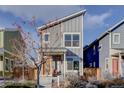 Two story grey home with modern architecture and a bright orange front door, set in a cozy neighborhood at 5863 N Boston St, Denver, CO 80238