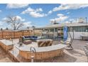 Inviting backyard patio featuring a stone bar, comfortable seating, and a charming hanging chair at 6190 Garrison St, Arvada, CO 80004