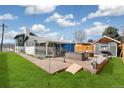 Large backyard patio with outdoor seating, well-maintained lawn, and attractive brick accents at 6190 Garrison St, Arvada, CO 80004
