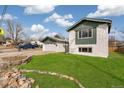 A well-kept front yard of a two-story home featuring green lawn and an rock and plant border at 6190 Garrison St, Arvada, CO 80004