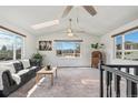 Bright living room with large windows offering scenic views, comfortable seating, and ceiling fans at 6190 Garrison St, Arvada, CO 80004