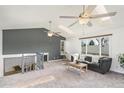 Open living room featuring vaulted ceilings, skylights, staircase, and comfortable seating, perfect for relaxation at 6190 Garrison St, Arvada, CO 80004