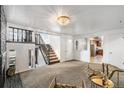 Cozy living room features a stairway, lots of light, and an open floor plan to the Kitchen at 6190 Garrison St, Arvada, CO 80004