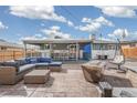 This stunning patio has ample seating, a dining area, and a built-in fire pit that is perfect for entertaining at 6190 Garrison St, Arvada, CO 80004