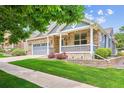 Charming brick home with a well-manicured lawn, a covered porch, and a two-car garage at 8225 W 67Th Pl, Arvada, CO 80004