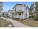 Inviting townhome row featuring light blue siding, covered entryways, and a well-manicured walkway at 6250 Everett Ct # F, Arvada, CO 80004