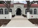 Stunning exterior with an arched doorway, tile roof, and decorative planters leading to the entrance at 4 Cherry Hills Farm Dr, Cherry Hills Village, CO 80113