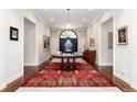 Elegant foyer with a decorative rug, wooden floors, and a statement table and blue vase at 4 Cherry Hills Farm Dr, Cherry Hills Village, CO 80113