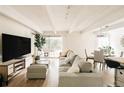 Open-concept living room with large sofa, TV, and sliding glass door to balcony, perfect for relaxing at 1365 Columbine St # 204, Denver, CO 80206