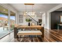 Elegant dining area with a large wooden table, bench seating, and a view of the backyard at 7875 S Grand Baker St, Aurora, CO 80016