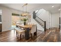 Stylish dining room with a wooden table, upholstered chairs, and a modern chandelier above at 7875 S Grand Baker St, Aurora, CO 80016