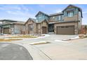 Beautiful two-story home with stone accents, a three-car garage, and a well-manicured lawn at 7875 S Grand Baker St, Aurora, CO 80016