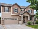 Charming two-story home with wood siding, stone accents, and a well-manicured lawn at 10371 Knollside Dr, Parker, CO 80134