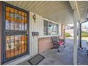 Inviting front porch with decorative ironwork, a cozy bench, and classic architectural details at 12060 W Carolina Dr, Lakewood, CO 80228