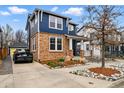 A blue two-story house featuring brick accents, a driveway, and attractive landscaping at 2949 Emporia Ct, Denver, CO 80238