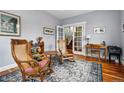 Inviting living area with hardwood floors, rocking chairs, and French doors leading to a staircase at 2949 Emporia Ct, Denver, CO 80238