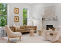 Bright living room featuring a modern fireplace, neutral furniture, large windows with natural light, and hardwood floors at 2351 N Emerson St, Denver, CO 80205