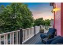 Relaxing balcony with views of the sunset, comfortable chairs, decorative lighting, and black composite decking at 2721 Curtis St, Denver, CO 80205