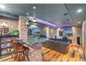 Entertainment basement featuring custom bar with seating, brick wall, and dual televisions at 2721 Curtis St, Denver, CO 80205