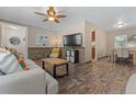 Open living space with hardwood floors, stone accent wall, and dining area at 7513 E Bates Dr, Denver, CO 80231