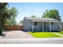 A quaint single-story home featuring a fenced yard and a comfortable outdoor seating area at 7870 Magnolia St, Commerce City, CO 80022